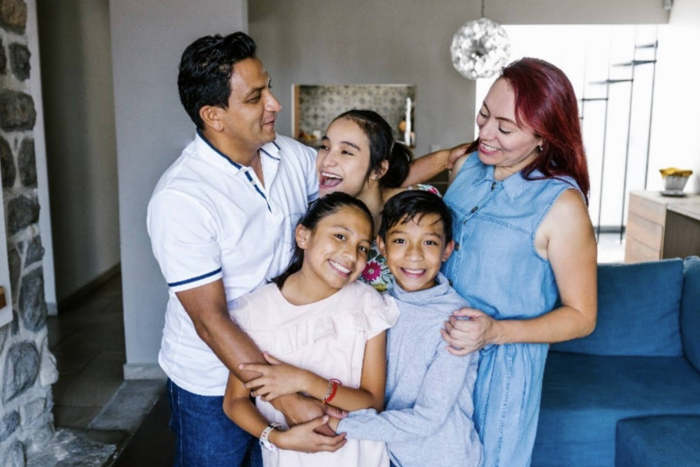 Happy hispanic family gathered together for a photo in their home.
