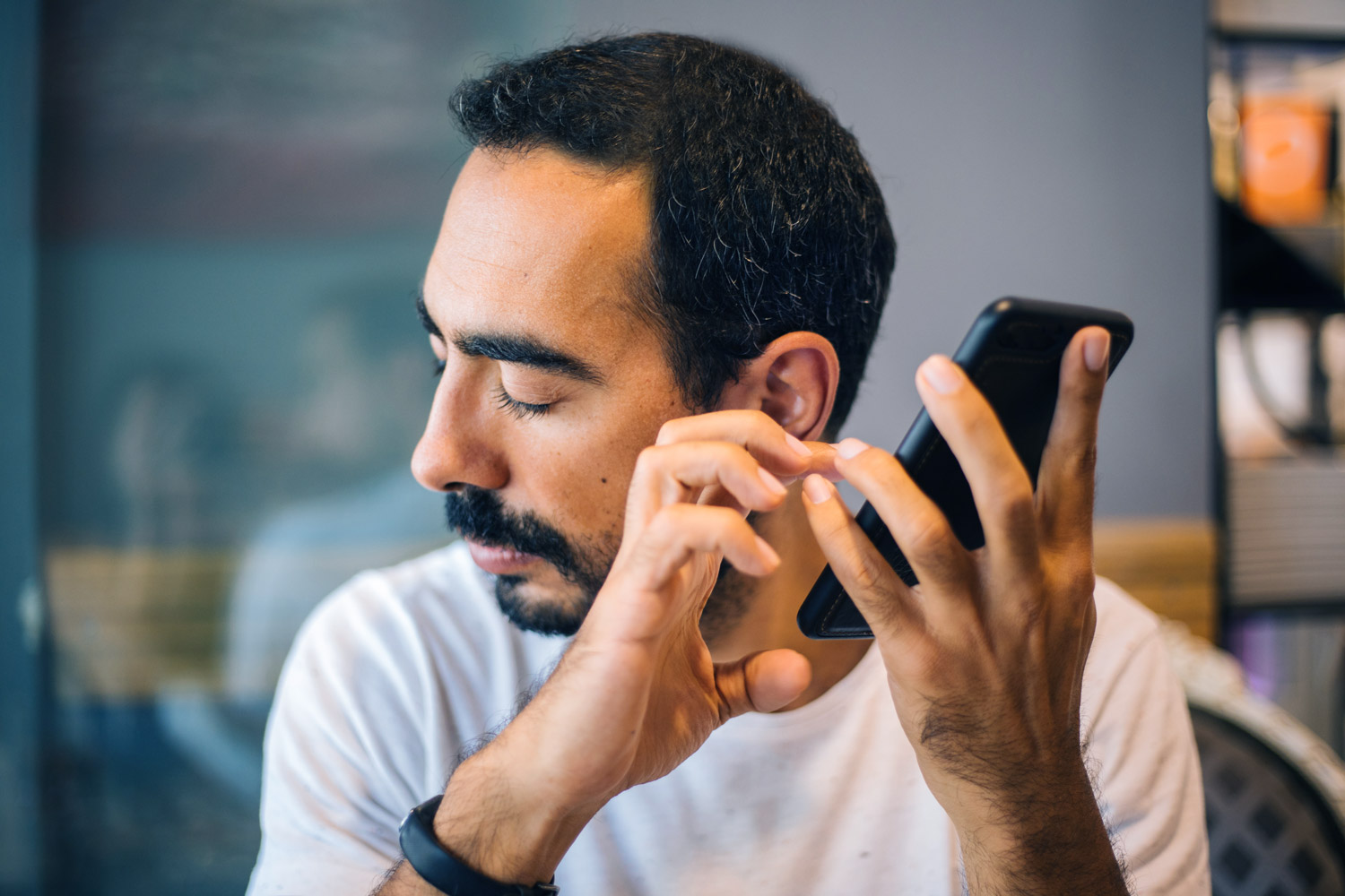 Blind man using cell phone with touch screen.
